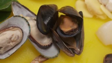 Yumuşakçalar, istiridyeler, Japon mutfağı kıvrımları sarı bir kesim tahtasının üzerinde yatıyor.