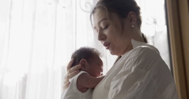 Anya Fehér Pólóban Tartja Babát Kezén Közelkép Beltéri Felvétel Ablak — Stock videók