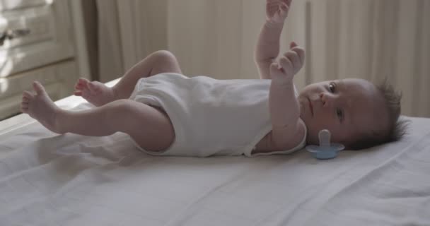 Novorozený Chlapeček Oblečený Bílém Těle Leží Zádech Bílém Prostěradle Vnitřní — Stock video