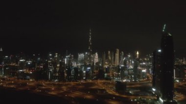 Gece Dubai üzerinden Burj Halife kulesine insansız hava aracı uçuşu.