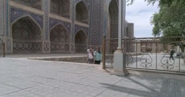 Lyab-i Hauz mimari topluluğu Buhara 'dan Khanaka Nadir Divan-Beghi. İnsansız hava aracı kamerası mozaik kaplamalı ön cephe boyunca yükselir ve sonunda eski şehir panoramasını çeker. Bulutlu bir havada çekilmiş.