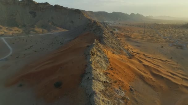 在落日的背景下 一架无人驾驶飞机在沙质沙漠中的岩石山脊上飞行 — 图库视频影像