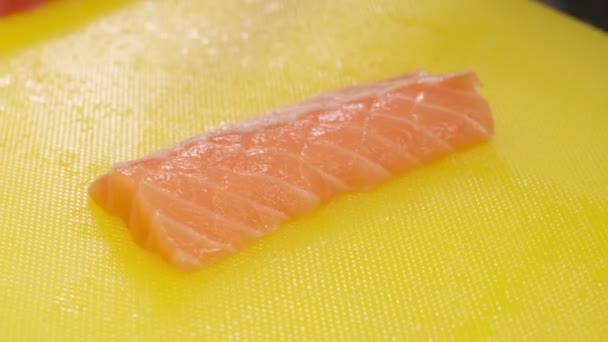 Chef Corta Pescado Rojo Rodajas Una Tabla Amarilla Con Cuchillo — Vídeo de stock