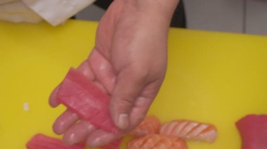 Somon, pirinç ve wasabi ile suşi yapıyorum. Şefin elleri yakın çekim.