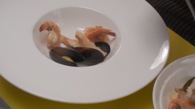 Daikon, limon dilimleri, yapraklar, kafayla kesilmiş balık ve siyah kare tabakta farklı türde kırmızı balık dilimleri ile suşi süslemek. Yakın çekim.