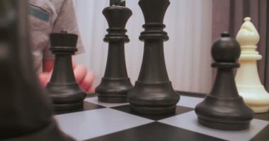 Çocuk satranç oynuyor. Satranç figürleri aşırı yakın plan. Satranç tahtası seviyesinde çekildi. Hareket eden kamera