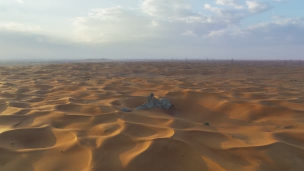 夕日を背景に砂漠の中の孤独な岩の周りの無人機の飛行 — ストック動画