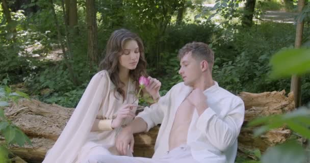 Pair Young Lovers Light White Robes Sit Log Garden Flowering — Vídeo de Stock