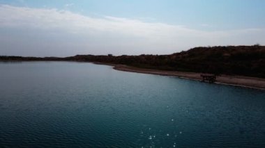Aydarkul Gölü kıyısında bir at sürüsü. İnsansız hava aracından yavaş çekim