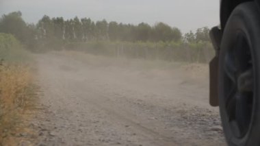 Kırsal bir yoldan geçen bir cipin geçen bir günde üzüm bağlarını geçerken yavaş çekimde çekilmesi.