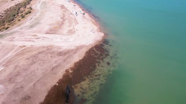 乾燥した草原の中 湖のほとりの漁師の上をドローンが飛ぶ — ストック動画
