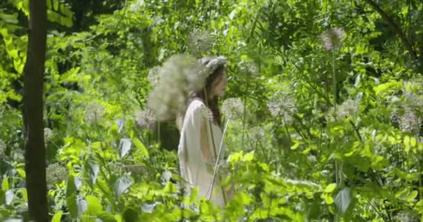 Young Woman Wreath Flowers Her Head Walks White Light Dress — Vídeo de Stock