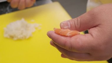 Somon, pirinç ve wasabi ile suşi yapıyorum. Şefin elleri yakın çekim.