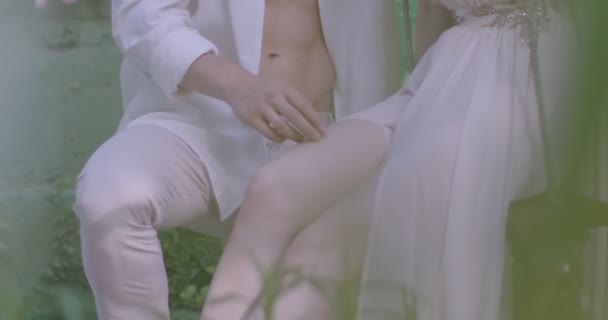 Young Couple Lovers Light White Robes Swing Blooming Spring Garden — Vídeo de Stock