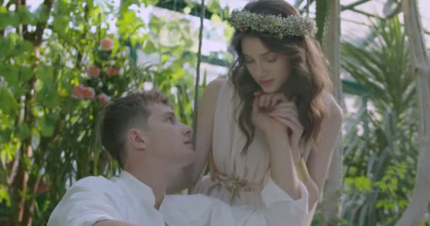Young Couple Lovers Light White Robes Swing Blooming Spring Garden — Stok video