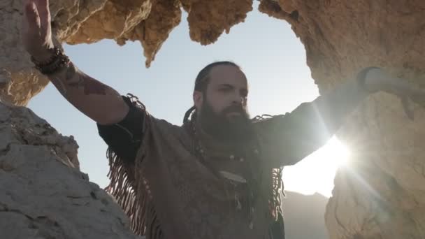 Молодой Бородатый Шаман Молится Стоя Гроте Скалы Среди Песчаных Дюн — стоковое видео