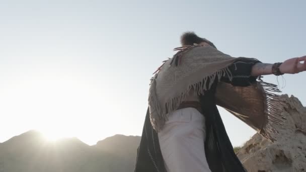 一个留着胡子的年轻萨满在落日的背景下 在沙漠的沙丘中祈祷 慢动作 阿联酋 — 图库视频影像