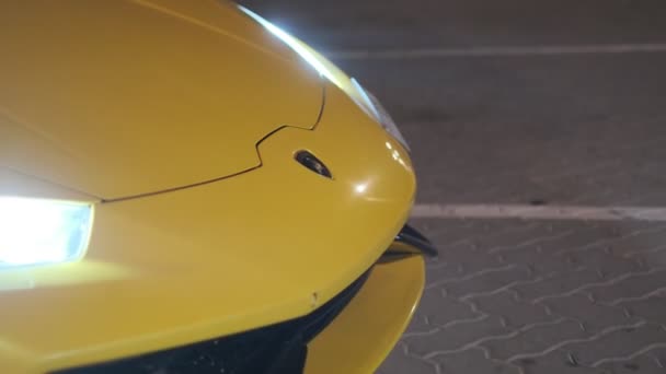 ドバイのナイトストリートにある黄色のスポーツカーのクローズアップ スローモーション — ストック動画