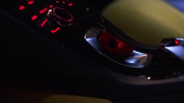 Genç bir kadın, pahalı bir spor arabanın başlama düğmesine basıyor. Yavaş Çekimi Kapat.