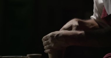 Çömlekçi ustasının elleri çömlekçi çarkında bulaşık üretiminde çalışıyor. Gerçek zamanlı, 4k.