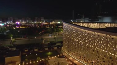 İHA 'nın parkın üzerinde bir gece uçuşu. İşleyen güzel bir çeşme, park inşaat halindeki otel ve evlerle çevrilidir. Hava görünümü