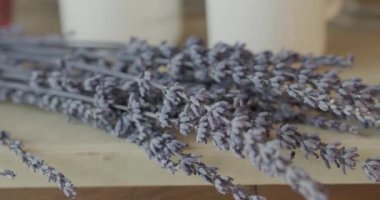 Dekorasyon için pahalı bir otelde güzel bir leylak çiçeği dalı masanın üzerinde yatıyor. Kapat, Yavaş Hareket.