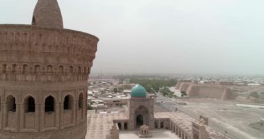 Şafak vakti Buhara 'daki ünlü Kalyan Poi Kalon Kompleksi ve Poi Kalon Minaret, Poi Kalan veya Po-i-Kalyan anıtında bir İHA uçar. Hava manzarası, Özbekistan