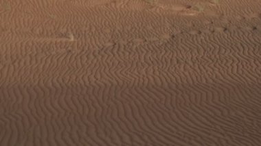 Gün batımında kum tepelerinde dalgalar, geçen bir SUV 'den, yavaş çekim.