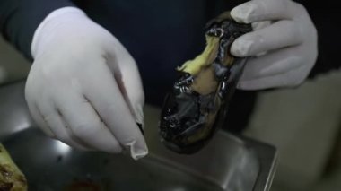 Beyaz eldivenli şef kavrulmuş patlıcan kabuğu. Kapat, Yavaş Hareket