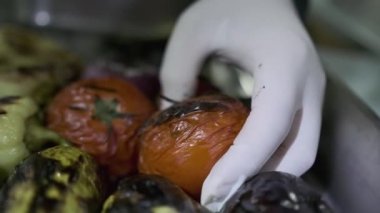 Beyaz eldivenli şef kavrulmuş domates kabuğu soyar. Kapat, Yavaş Hareket