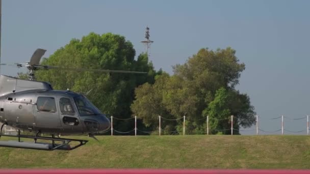 青い空に対する小さな民間ヘリコプターがドバイの飛行場に着陸する準備をしています スローモーション — ストック動画