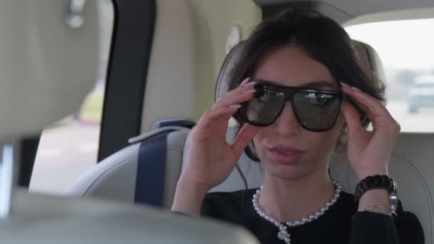 Mulher Morena Jovem Vestido Preto Elegante Óculos Sol Cabine Uma — Vídeo de Stock
