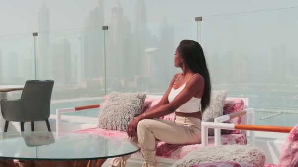 ドバイ Uaeを見下ろすガラスバルコニーでビジネスホワイトズボンのスーツでスワース若い女性 スローモーション — ストック動画