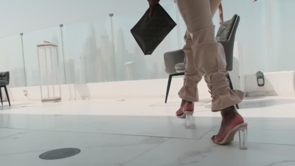 ドバイ Uaeを見下ろすガラスバルコニーでビジネスホワイトズボンのスーツでスワース若い女性 スローモーション — ストック動画