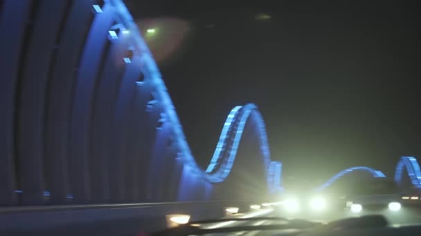 アラブ首長国連邦ドバイのライトアップされた夜の橋の上に立っている車のパノラマ スローモーション — ストック動画
