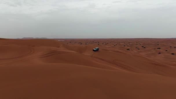 無人機は砂漠の砂丘を通ってジープの上を飛ぶ 空中風景 — ストック動画