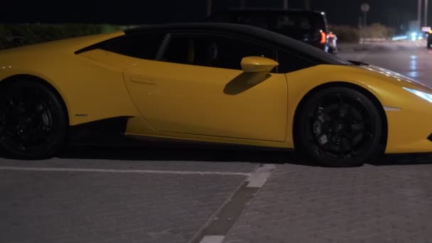 高価なスポーツ黄色の車は夜の通りの駐車場から移動し 戻ってきます スローモーション — ストック動画