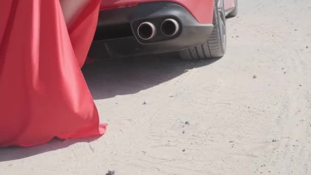 Egy Hosszú Ruhás Fiatal Odasétál Egy Piros Drága Sportkocsihoz Homokon — Stock videók