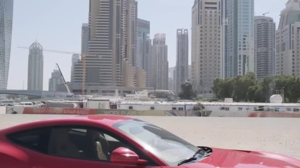 Röd Dyr Sportbil Står Sanden Vallen Mot Bakgrund Dubais Skyskrapor — Stockvideo