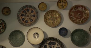 Seramikçi ressamın galerisindeki duvarda asılı seramik tabaklar var. Gerçek zamanlı, 4k.