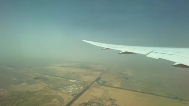 Kanatlarındaki uçağın videosu, altındaki Dubai toprakları ve ufuktaki toz fırtınası. Hava görünümü