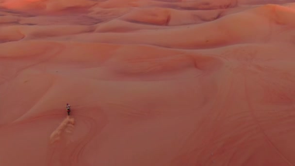 スポーツバイクのバイク乗りは アラブ首長国連邦の砂漠の砂丘を通っています ドローン航空 — ストック動画