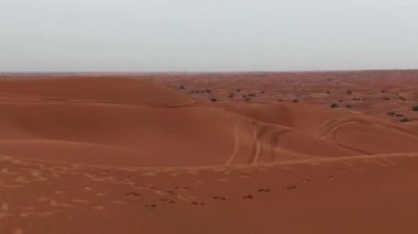 Bulutlu bir günde Dubai 'deki çölün kum tepelerinde uçan bir dron. Hava görünümü