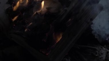 Doğu tarzı antik bir binada geceleri kuru gazilerin ateşinde yanan açık bir kitap. Yavaş Çekim, Süper Yakın