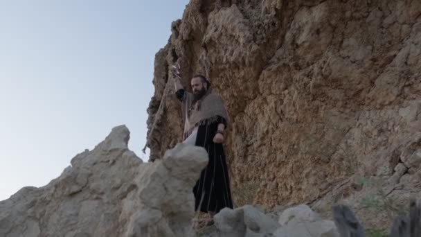 Чоловік Палицею Руці Одягом Шамана Стоїть Скелі Серед Пісень Пустелі — стокове відео
