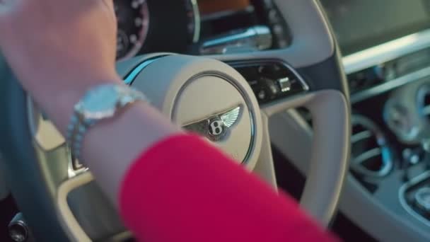 ドバイ Uae 2023 熟したジーンズと高価な高級車の車輪の後ろに座っている赤いセーターの若い女性 スローモーション — ストック動画