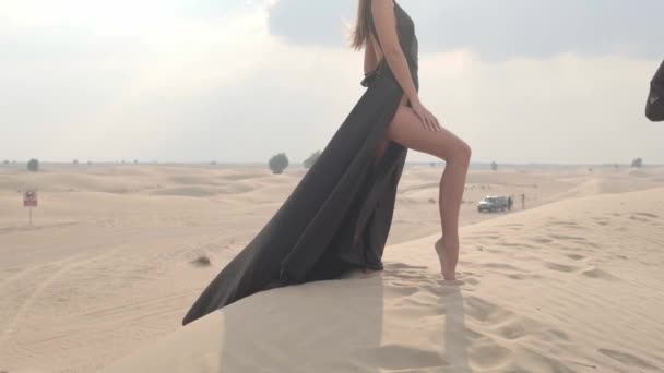 Uzun Saçlı Şık Siyah Elbiseli Genç Bir Kadın Çöl Kumunda — Stok video