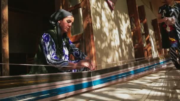 タシェント ウズベキスタン 2022 古代の技術を使用して手作りのカーペットを織るウェーバーの手のクローズアップ — ストック動画