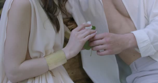 Pair Young Lovers Light White Robes Sit Spring Garden Hold — Stockvideo
