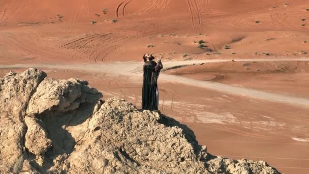 Muž Holí Ruce Oděvem Šamana Stojí Skále Mezi Písky Pouště — Stock video